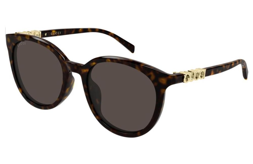 Gucci round sunglasses with a dark brown tortoiseshell acetate frame, dark gray lenses, and gold-tone metal hardware featuring the brand name.