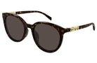 Gucci round sunglasses with a dark brown tortoiseshell acetate frame, dark gray lenses, and gold-tone metal hardware featuring the brand name.