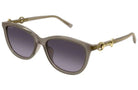 Gucci cat-eye sunglasses with a translucent taupe frame, gold-tone hardware, and gradient gray lenses, shown on a plain white background.