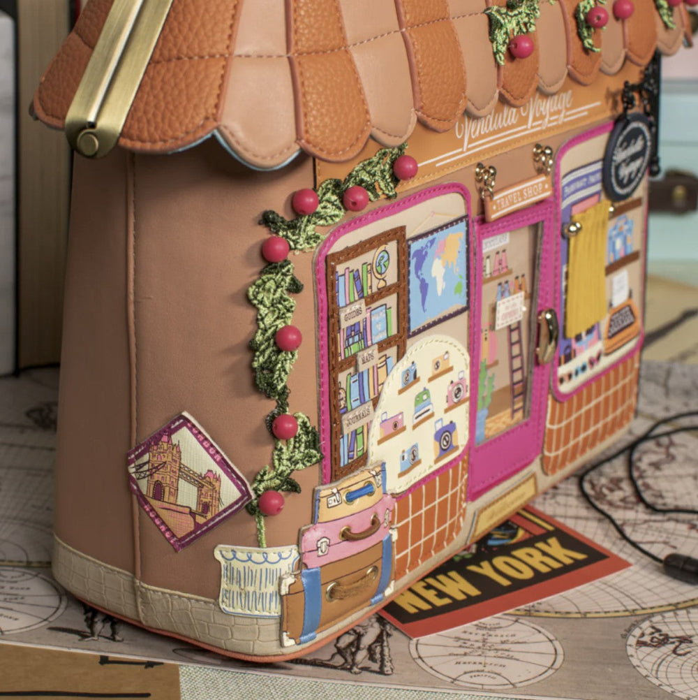 Decorative handbag with a detailed design of a bookshop and 'New York' sign.