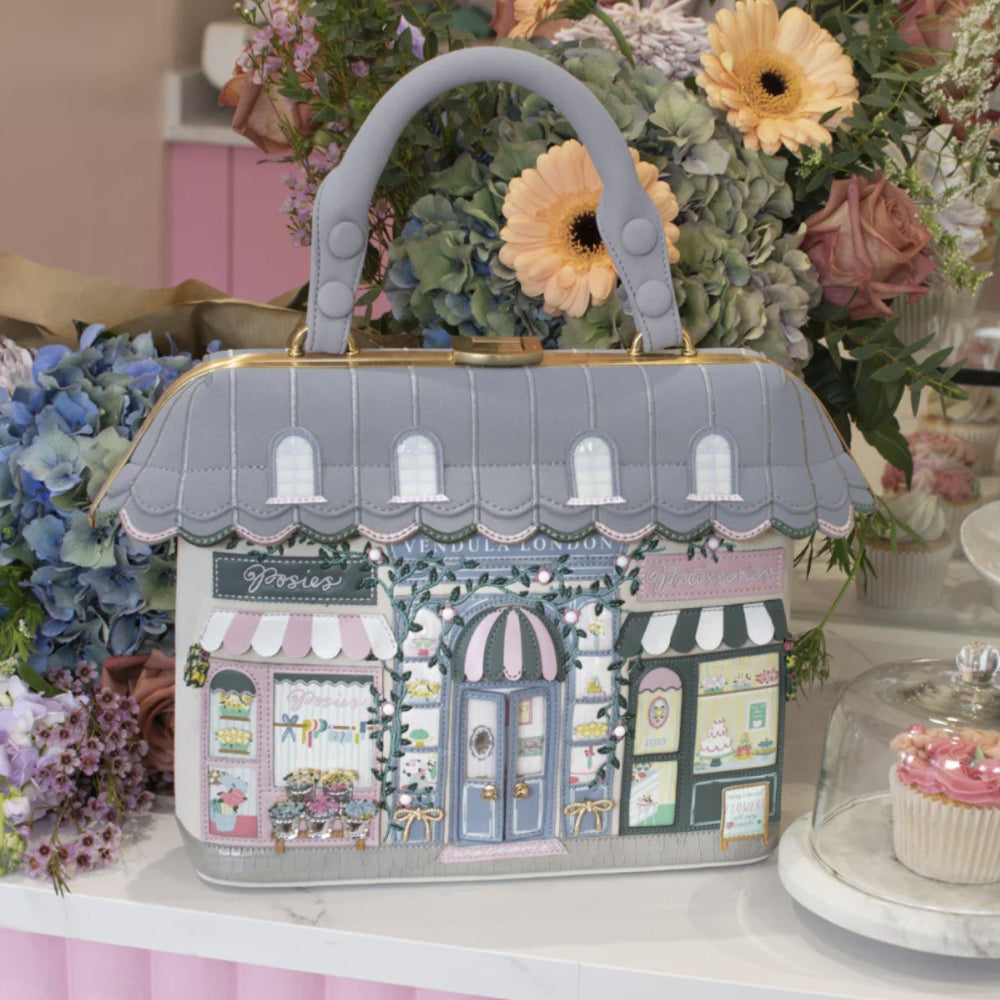 Handbag designed with shop fronts, surrounded by flowers.