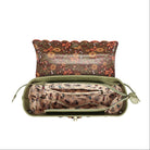 An open olive green handbag with a floral patterned exterior and a beige patterned interior organizer pouch.