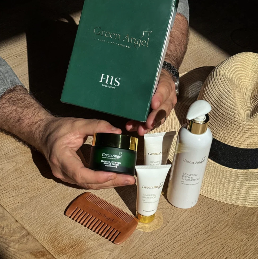Collection of Green Angel men's grooming products on a wooden surface with a hat and comb.