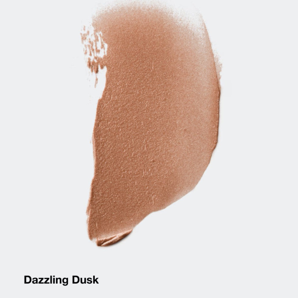 Nude-colored makeup swatch labeled 'Dazzling Dusk' on a light gray background