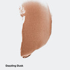 Nude-colored makeup swatch labeled 'Dazzling Dusk' on a light gray background