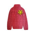 Pink knitted sweater with a yellow flower brooch on a white background
