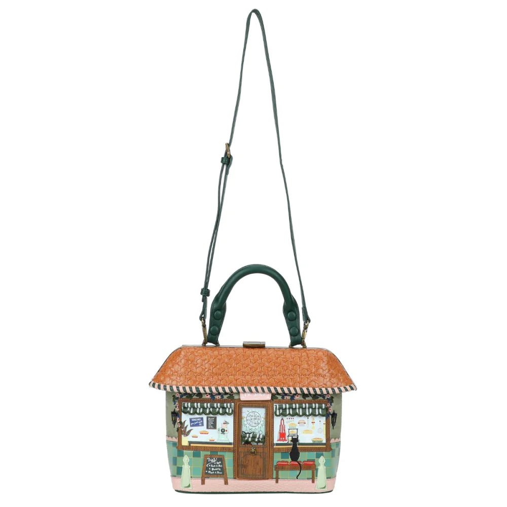 Handbag designed like a small building with a straw roof on a white background