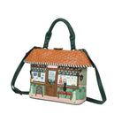 Handbag designed like a small building with a green roof and decorative elements on a white background