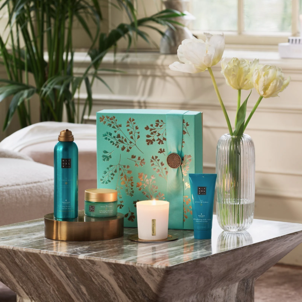 Cosmetic products on a table with a decorative box and flowers in a room.