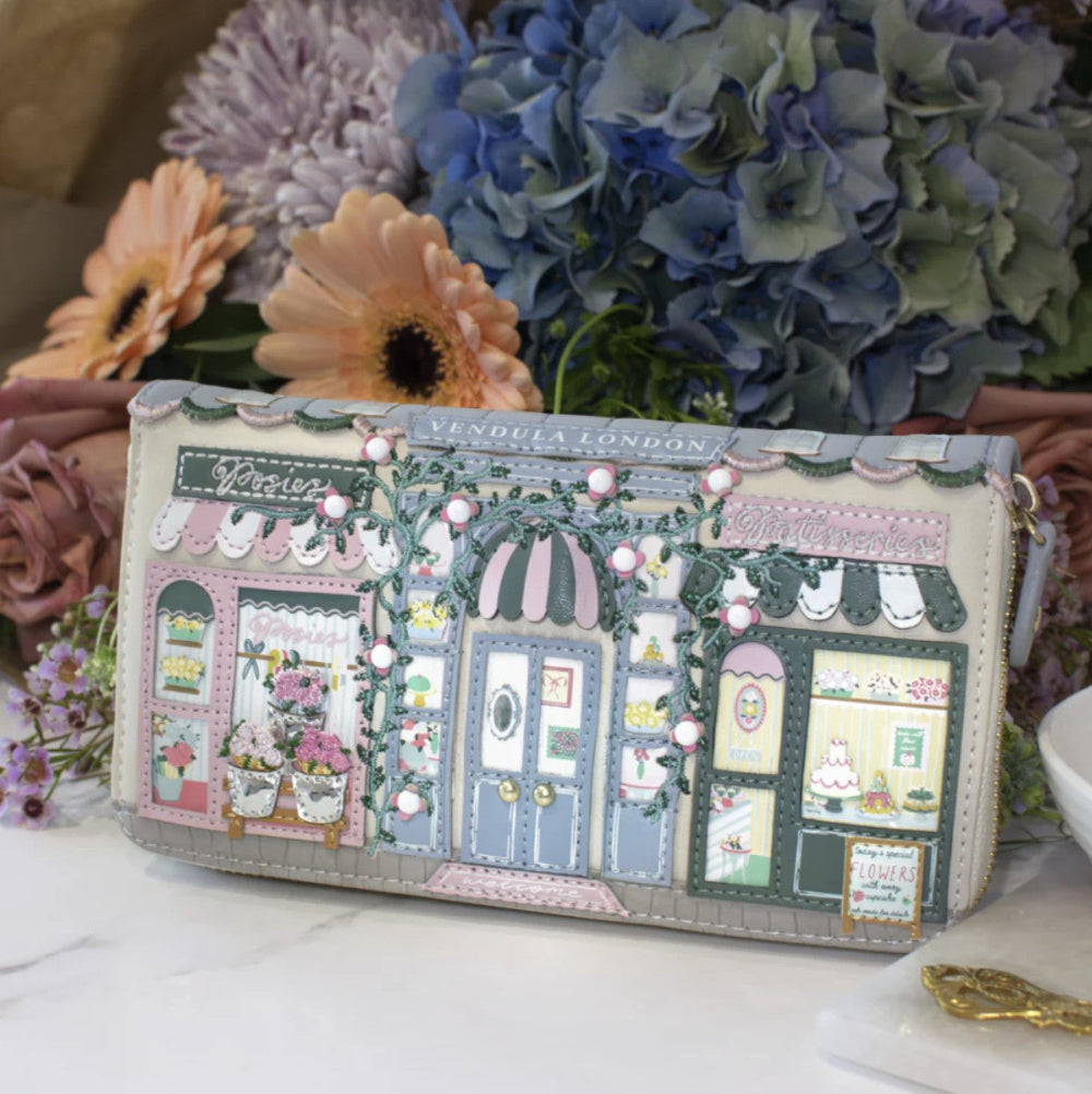 Designer handbag with detailed facade design in front of flowers
