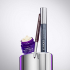 Clinique skincare products including a jar, brush, and bottle on a reflective surface.