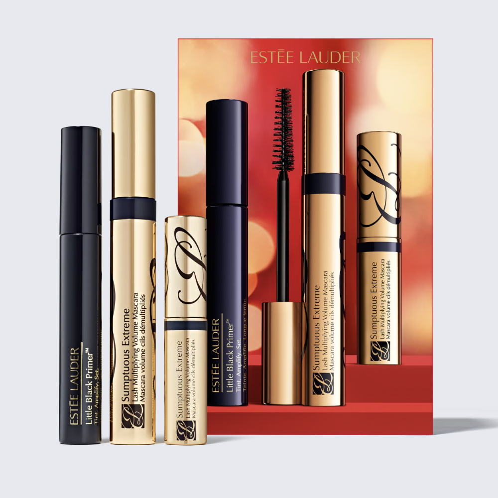 Estée Lauder makeup set featuring three cosmetic tubes and a matching red gift box on a light gray background. The set includes Little Black Primer in black packaging, Sumptuous Extreme in gold packaging