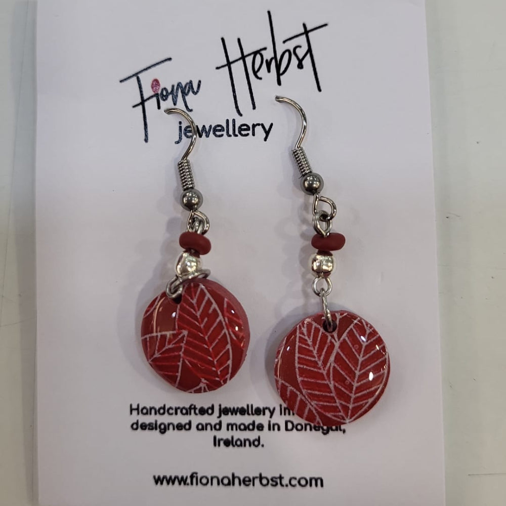 Red earrings on a card with Fiona Herbst branding