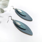Pair of blue feather-shaped earrings on a white background