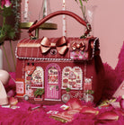 Decorative red handbag with heart designs on a pink background