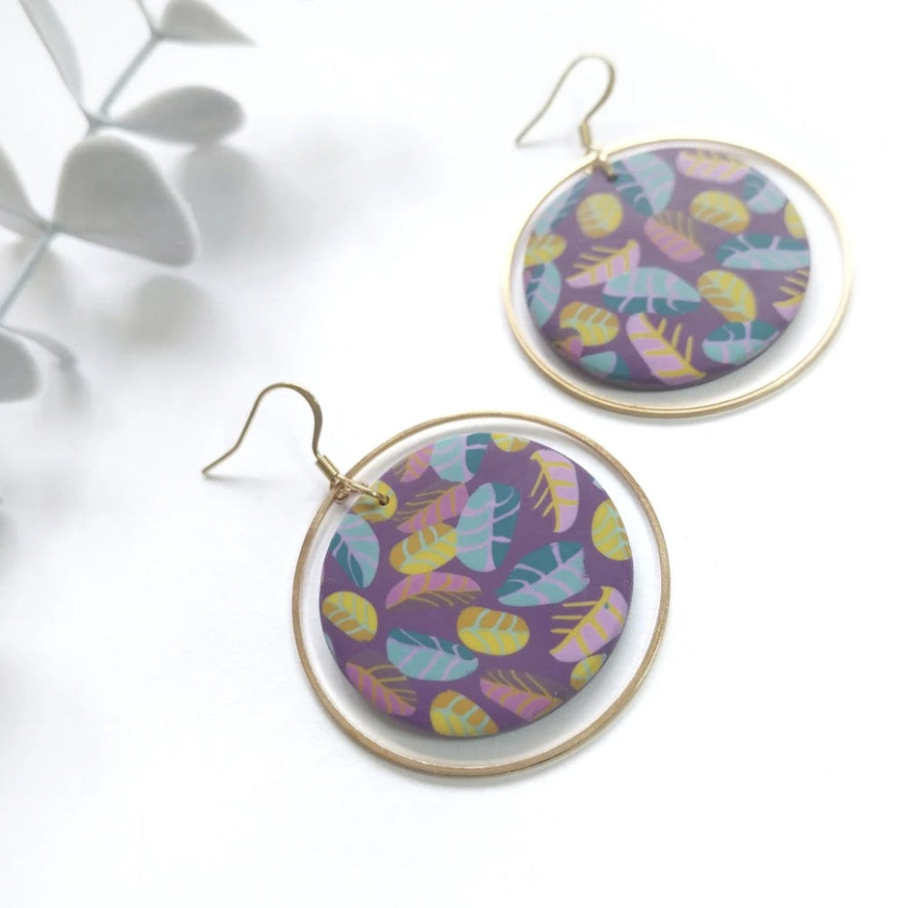 Pair of round earrings with colorful pattern on a white background