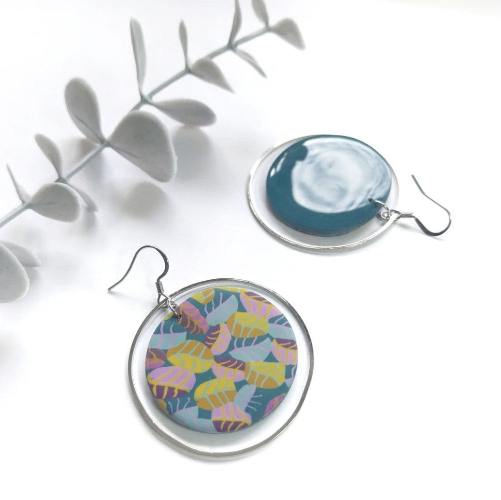 Two earrings with colorful designs on a white background
