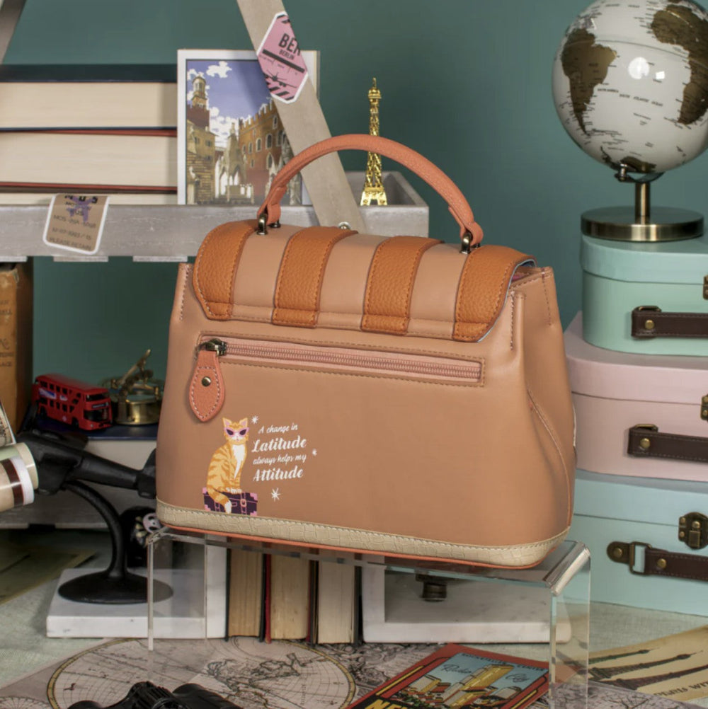 Brown handbag with a fox design on a surface with travel-themed decor