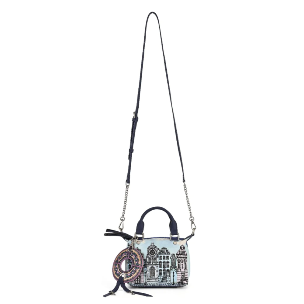A light blue handbag with a black and white architectural illustration, featuring a long black shoulder strap with silver chain links, a top handle, and a decorative circular charm.