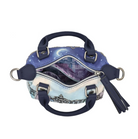 A small structured handbag shown open against a plain white background. The exterior features a blue and purple celestial print with a cityscape illustration near the bottom, navy blue leather handles and trim, silver-tone hardware, and a navy tassel charm.