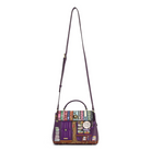 A purple leather handbag with a colorful book-themed illustration on the front flap and a long shoulder strap, shown against a plain white background.
