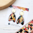 Colorful geometric earrings on a branded card with a terrazzo pattern.