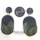 Pair of black and green earrings on a white card with 'Duil' branding.