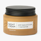 Jar of night cream with black lid on a white background