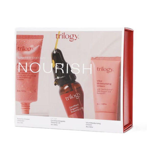 Trilogy Nourish Limited Edition skincare gift set in a white box with red side panels, showing three products: a pink cleanser tube, a dark amber serum dropper bottle, and a pink moisturizing cream tube.
