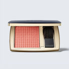 Makeup blush compact with a brush on a light gray background