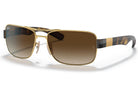 Gold-framed sunglasses with brown gradient lenses on a white background