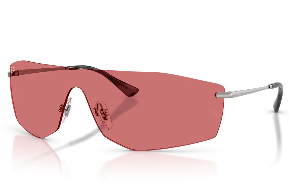 Rimless shield-style sunglasses with a large pink-tinted lens and silver metal temples