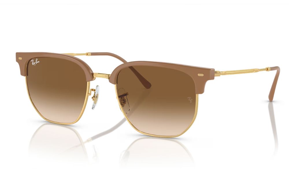 Sunglasses with brown gradient lenses and gold frame on a white background