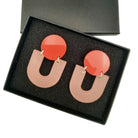 Pair of earrings with pink and orange design in a black box
