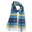 A plaid scarf in shades of blue, navy, yellow, and green, featuring fringed ends and a small white brand label near the bottom left, set against a plain white background.