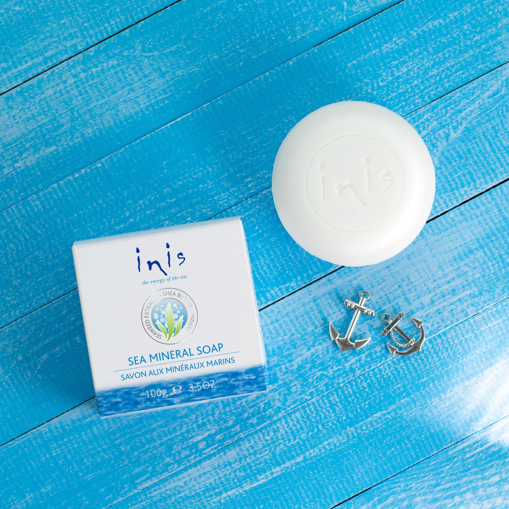 Sea mineral soap with packaging and anchor decorations on a blue wooden surface