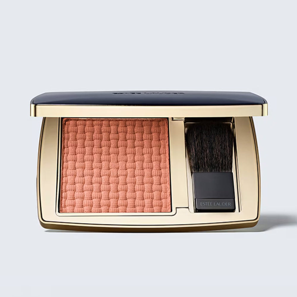 Estée Lauder bronzer compact with brush on a light gray background