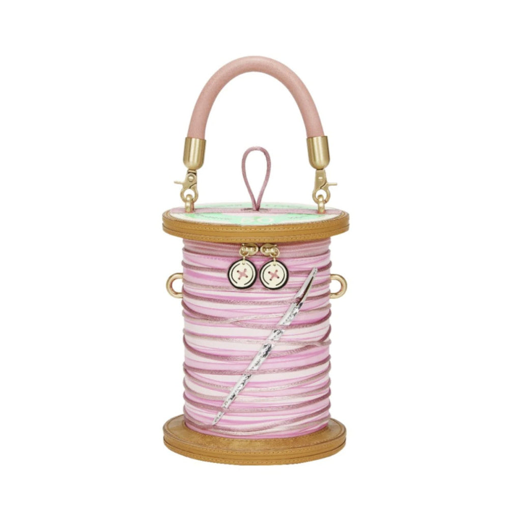 Pink spool-shaped bag with a needle on a white background