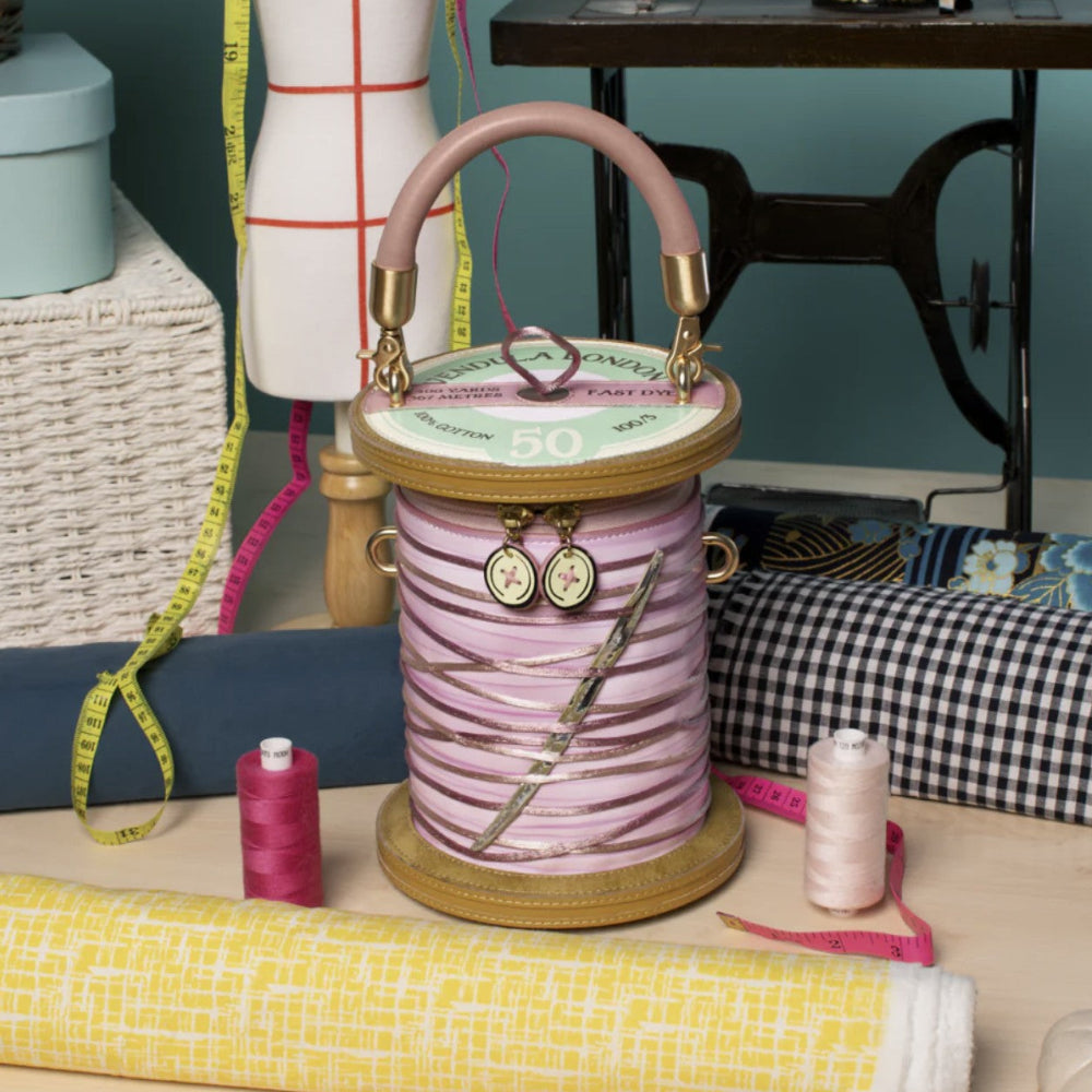 Spool of thread bag with decorative elements on a sewing-themed background