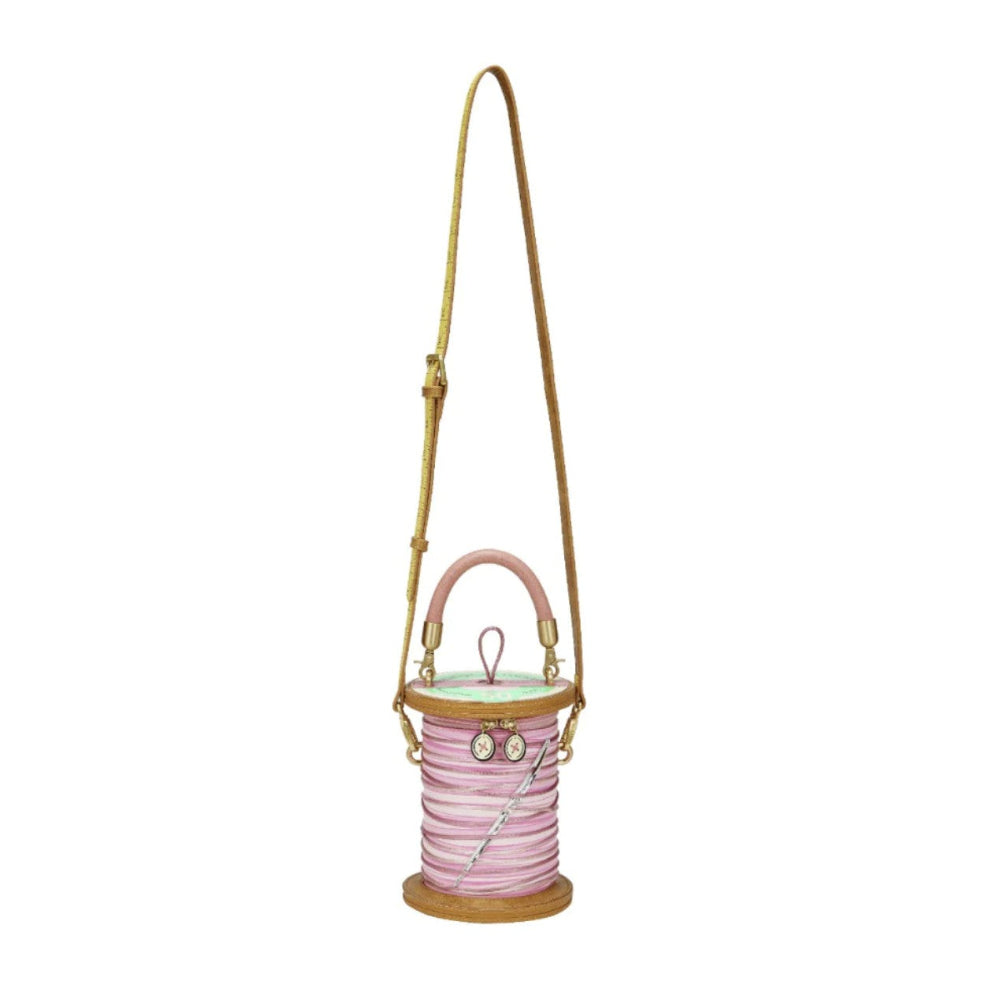 Pink spool bag with a beige strap on a white background