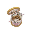 Spool of thread with a decorative top on a white background