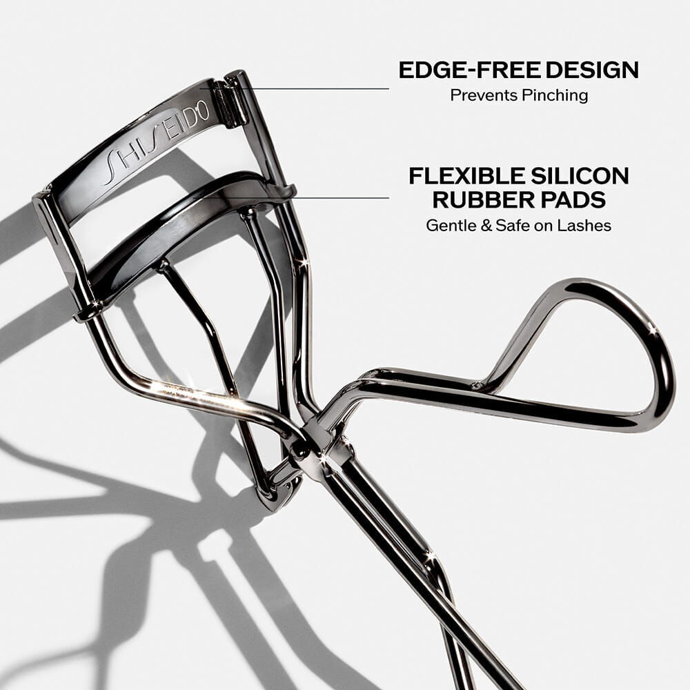 Shiseido eyelash curler with labeled features on a white background
