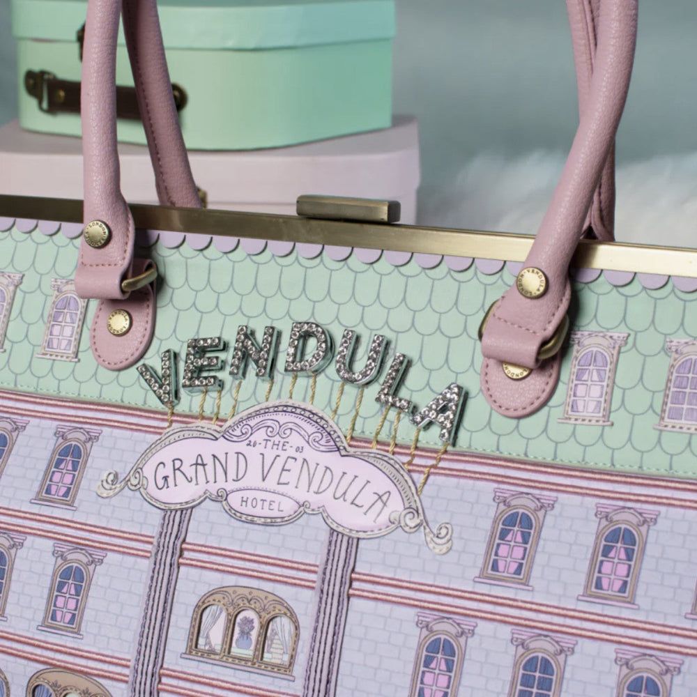 Handbag with 'Vendula' and 'Grand Vendula Hotel' design on a light green background