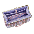 Open fabric suitcase with purple interior and pink handles on a white background