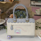 Handbag with scalloped edges on a decorative background with flowers and cupcakes.