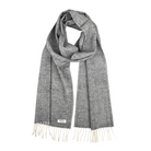 A gray and white heathered knit scarf with cream-colored fringe ends and a small white brand label near the bottom left, displayed on a solid white background.