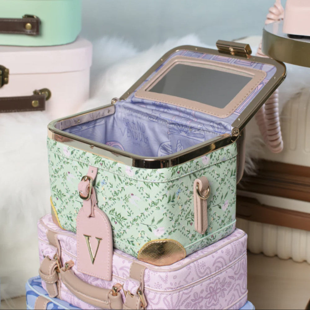 Stack of vintage-style suitcases with floral patterns and decorative tags.