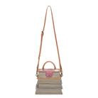 Handbag with a pink top section and brown strap on a white background