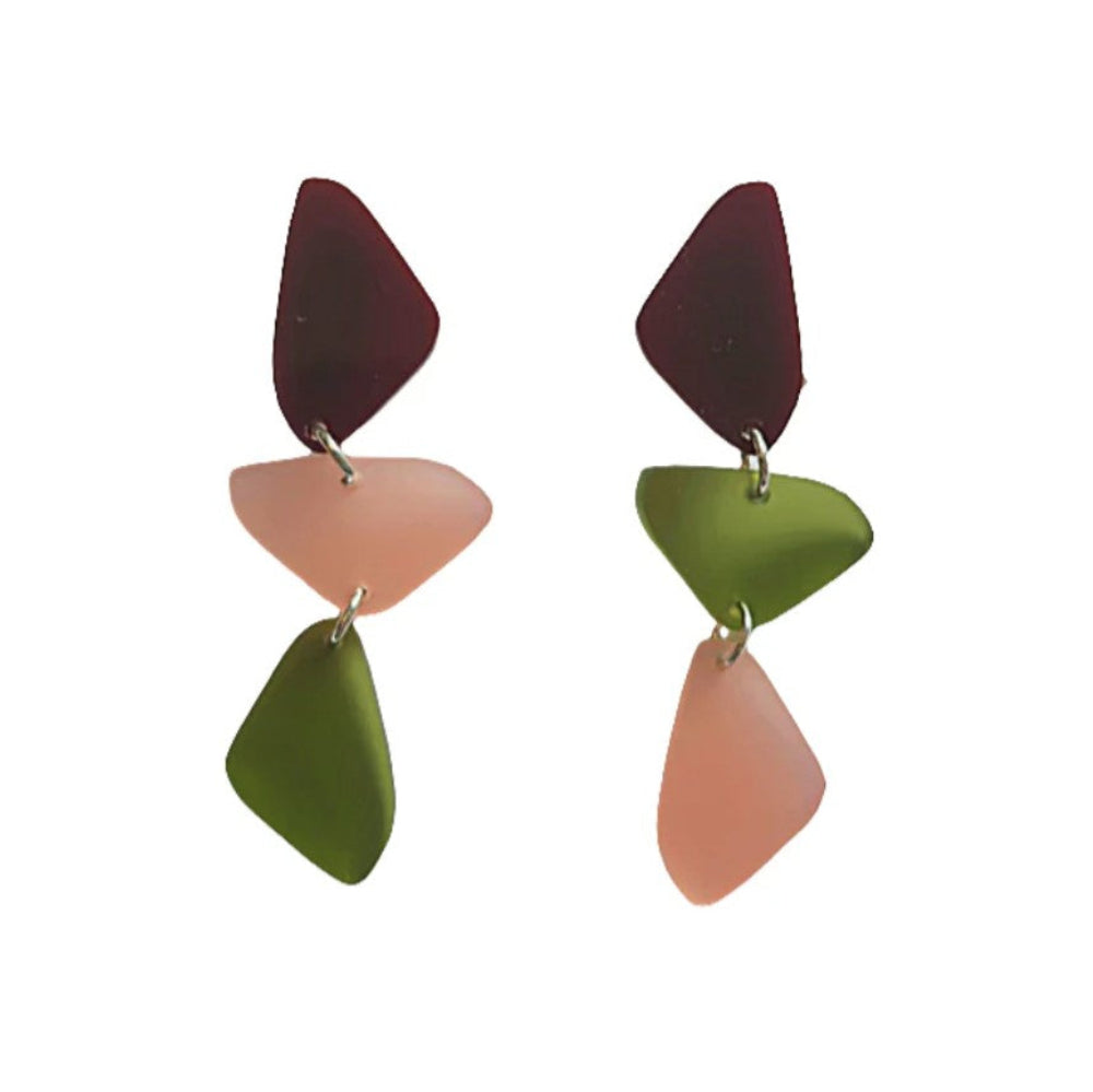 Pair of earrings with geometric shapes in red, green, and pink on a white background
