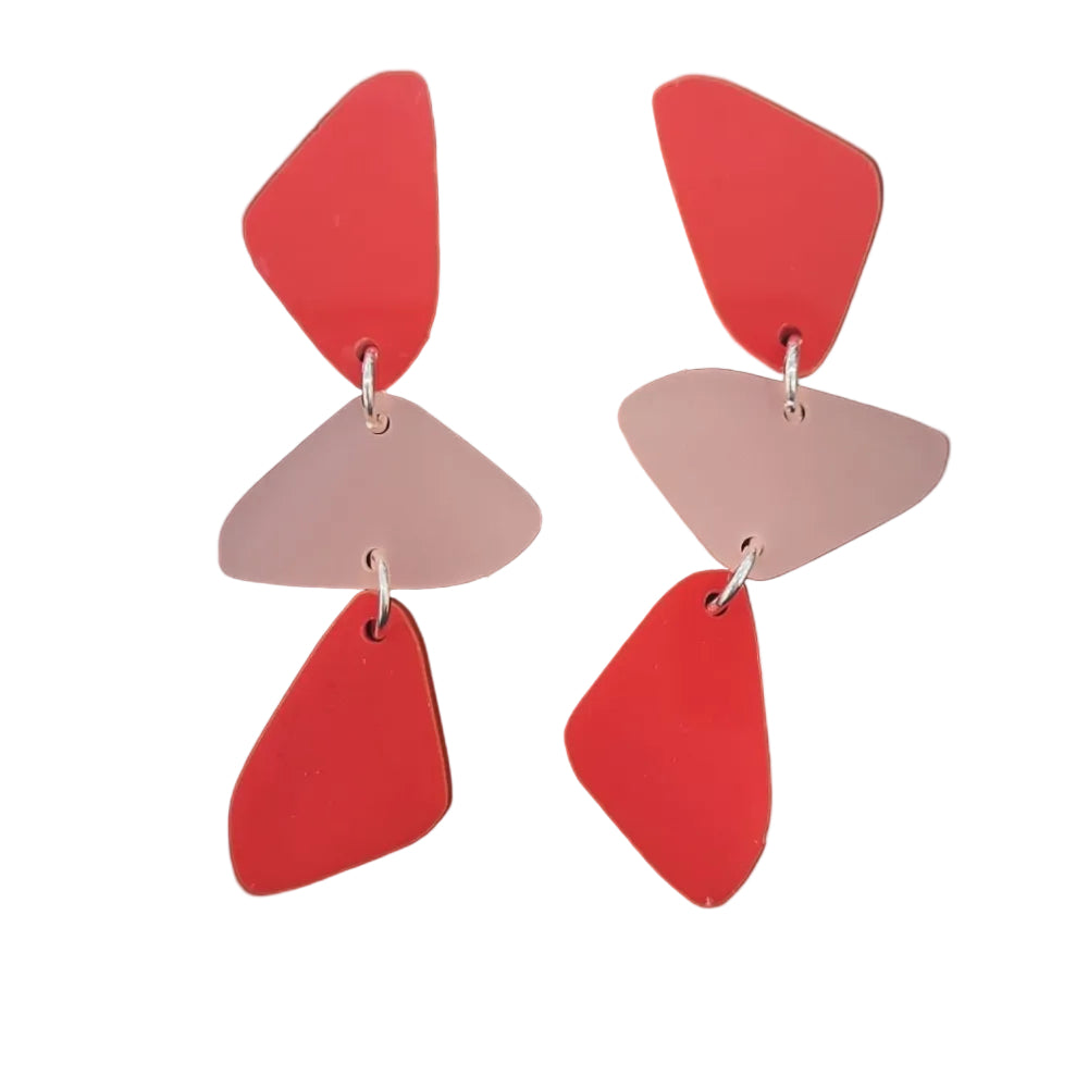 Pair of earrings with geometric shapes in red and rose pink on a white background